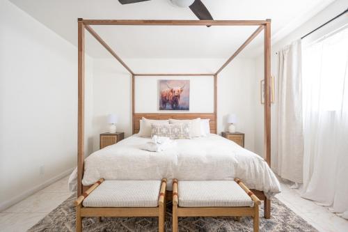 劳德代尔堡Lighthouse Guest Suites的一间卧室配有一张带两把椅子的天蓬床