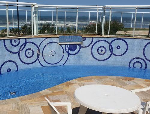 伊塔尼亚恩Resort Itanhaém - Pé na areia的一个带桌子和桌椅的游泳池