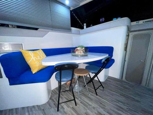 基拉戈Nice Boat in Key Largo的小厨房配有蓝色的沙发、桌子和凳子
