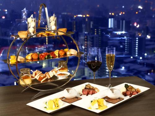札幌札幌王子酒店的一张桌子,上面放着一盘食物和酒杯