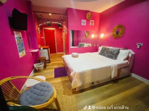 格兰岛บ้านเนวี่ เกาะล้าน的粉红色的卧室设有一张大床和一台电视机