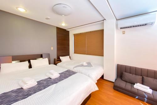 东京Uhome Mitomi Home 3F的一间带两张床和一张沙发的卧室