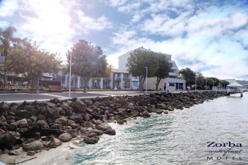 巴特曼斯贝佐巴海滨汽车旅馆的建筑物前有岩石的河流