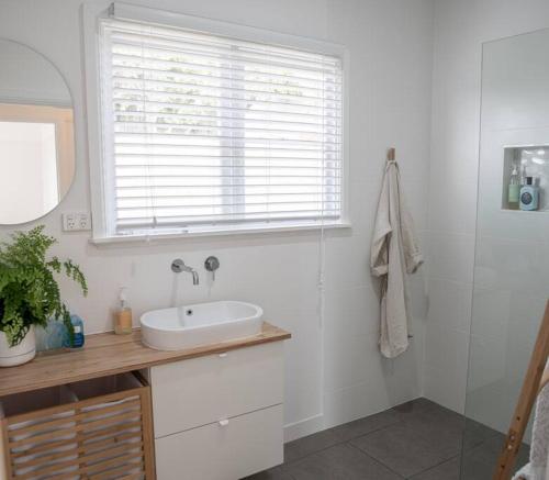 沃纳姆堡Barkly Beach House Warrnambool的白色的浴室设有水槽和窗户。