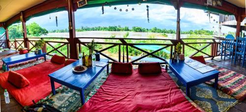 东德岛Don Det Sokxay and Mamapieng Budget Guesthouse的一间设有两张蓝色桌子的房间,享有田野的景色