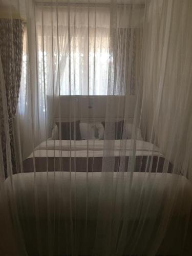 基苏木Mountainview house#122的卧室内的一张带白色窗帘的床