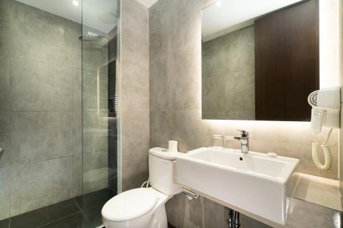 茂物Swiss-Belinn Bogor的一间带卫生间、水槽和镜子的浴室