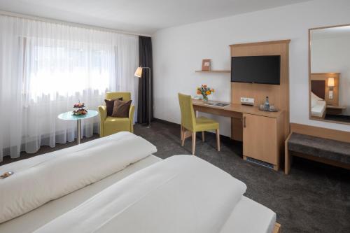 巴特博尔索妮哈德乡村酒店的配有一张床和一张书桌的酒店客房