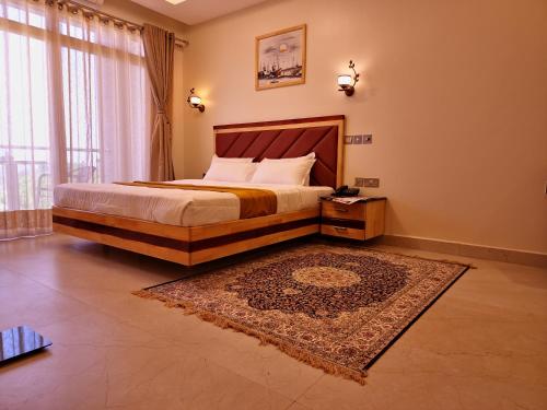 AruaDreamland Hotel的一间卧室配有一张大床和地毯。
