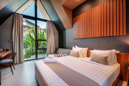 坎古Le Cielo Resort Umalas by Maviba的一间卧室设有一张大床和一个窗户。