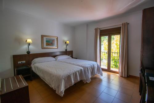 普拉多德尔雷Hotel del Carmen的一间卧室设有一张床和一个大窗户