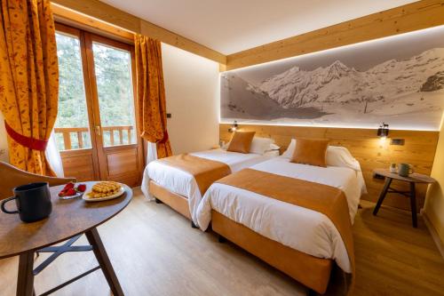 尚波吕克培缇图娜琳酒店的酒店客房设有两张床和一张桌子。