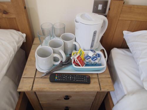 伦敦伯爵府花园酒店的一张桌子、咖啡壶和床上的杯子