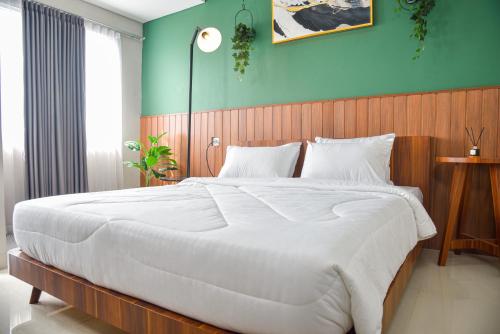 KedungmangguStay G Service Residence Sentul的一间卧室配有一张白色大床和蓝色的墙壁