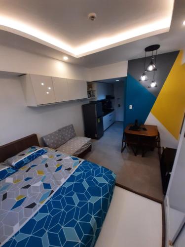 宿务1809 Sunvida Tower Condo across SM City Cebu的一间带蓝色床的卧室和一间厨房