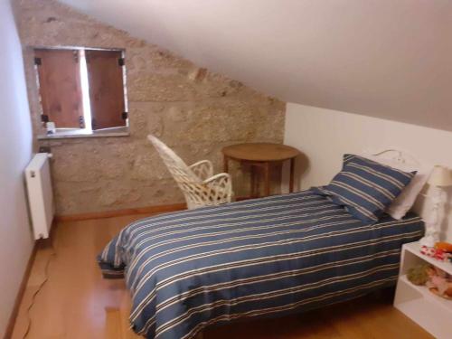 瓜尔达Casas do Minério的一间卧室配有一张带蓝白条纹毯子的床