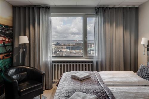 赫尔辛堡Dream - Luxury Hostel的一间卧室配有一张床、一把椅子和一个大窗户