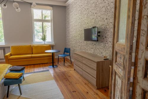 莱什诺Atelier Hostel的客厅配有沙发和墙上的电视