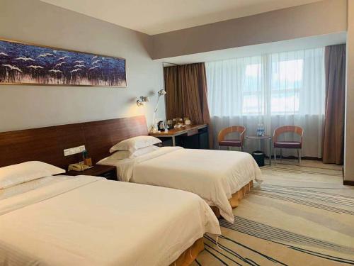 广州广州戴斯酒店的酒店客房配有两张床和一张书桌