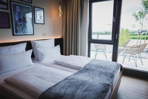 MommenheimWeinzuhause Hotel-Restaurant-Vinothek的一间卧室设有一张床,享有庭院的景色