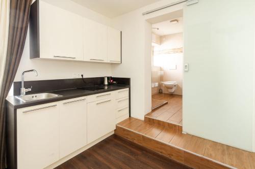 罗西斯S'Matt的厨房配有白色橱柜、水槽和卫生间。