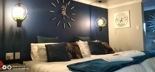 帕罗Mitchell's Guesthouse的卧室配有一张大床,墙上挂着时钟