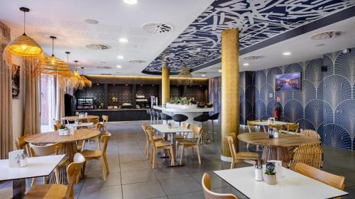 圣埃尔布兰Akena Nantes Atlantis Zénith的一间带桌椅的餐厅和一间酒吧