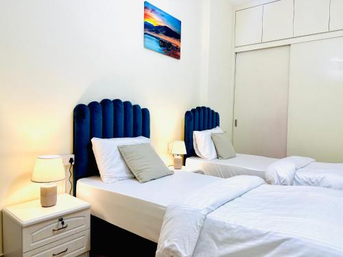 迪拜VIP Hostel - Females Only的客房内的两张床和蓝色床头板