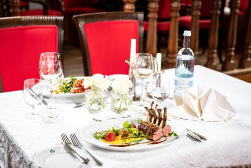 Ludorf卢多夫罗曼蒂克酒店的一张桌子,上面放着两盘食物和酒杯