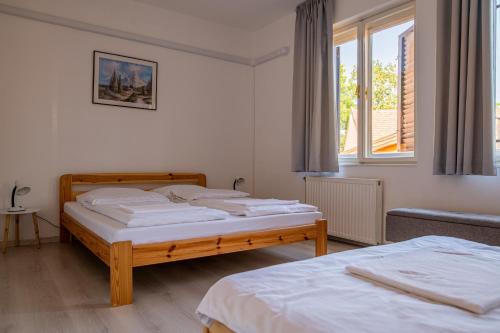 塞格德Barát Vendégház - Cosy Guesthouse - Teljes ház privát udvarral - 4 szoba, 2 fürdő的一间卧室设有两张床和窗户。