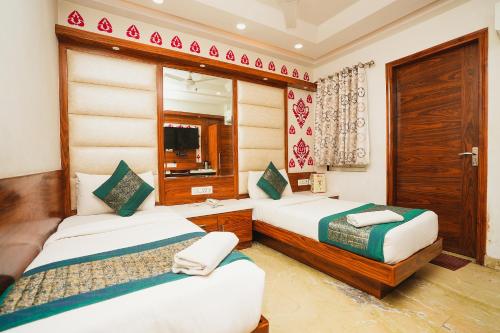 新德里Hotel Kabir Palace Karol Bagh的酒店客房,设有两张床和镜子