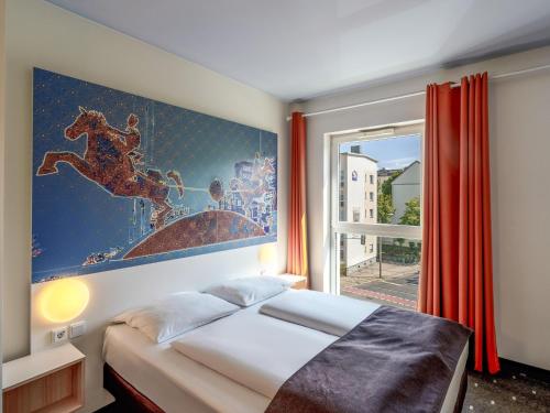 马格德堡B&B HOTEL Magdeburg-City的卧室配有一张床,墙上挂着一幅大画