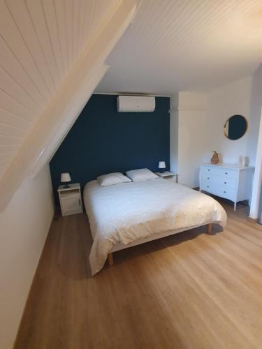 阿让塔" Les copains d'abord "的一间卧室设有一张床和蓝色的墙壁