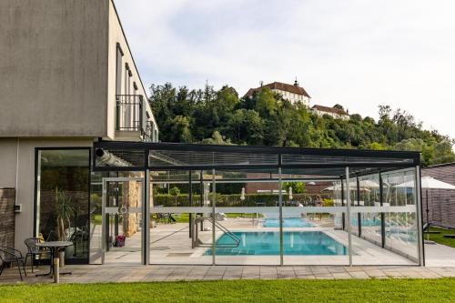 巴特拉德克斯堡奥地利帝王历史温泉酒店的一座带游泳池的房屋的玻璃延伸部分