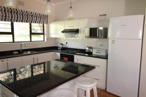 马盖特Seagull Road 838的厨房配有白色家电和黑色台面
