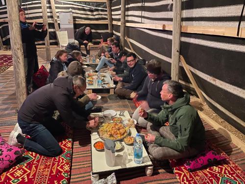 米茨佩·拉蒙חאן נחל חווה Han Nahal Hava的一群坐在桌子旁吃食物的人