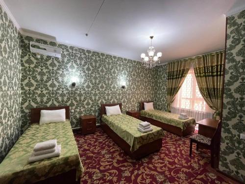 希瓦Shokhjakhon Parvoz的一间卧室配有两张床和吊灯。