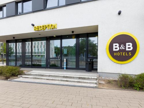 杜伊斯堡B&B Hotel Duisburg Hbf-Süd的一座大建筑,上面有酒店标志