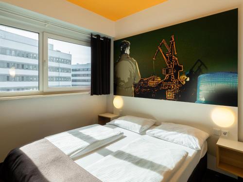 杜伊斯堡B&B Hotel Duisburg Hbf-Süd的卧室配有一张床,墙上挂有绘画作品