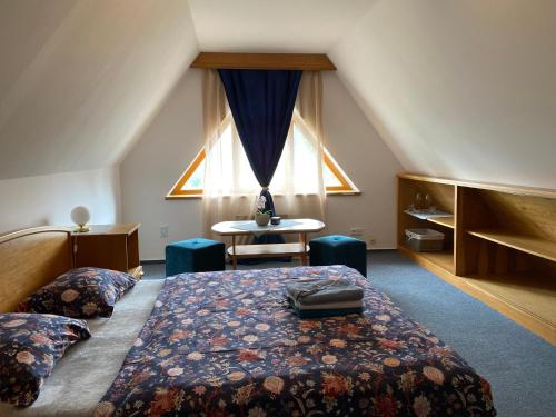 斯尼Samoobslužný hotel Vydra的一间卧室配有一张床、一张桌子和一个窗户。