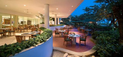 加拉班塞班凯悦酒店的庭院内的餐厅,配有桌椅