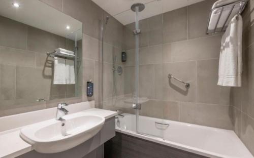 戈尔韦克莱顿戈尔韦酒店的浴室配有盥洗盆、浴缸和盥洗盆