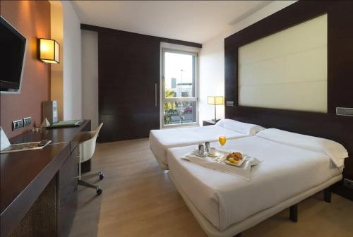 波苏埃洛-德阿拉尔孔欧洲之星马德里酒店的酒店客房设有一张大床,上面放着一盘食物