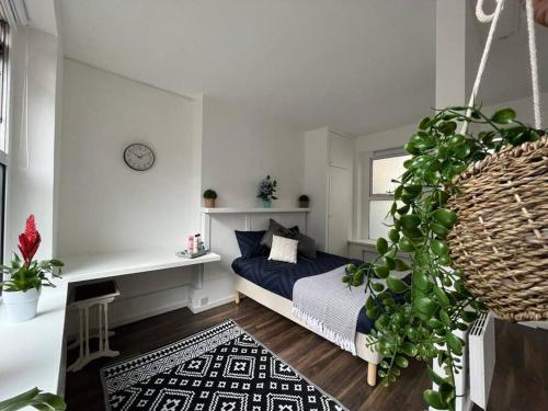 伦敦Glasshouse yard studio's F1的一间卧室配有一张床和盆栽植物