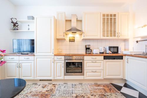 因斯布鲁克Apartment "Deluxe" Innsbruck - Mutters的厨房配有白色橱柜和炉灶。
