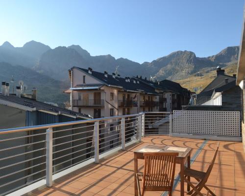 帕斯底拉卡萨Pierre & Vacances Andorra Pas de la Casa Alaska的阳台配有两把椅子和一张桌子,位于屋顶