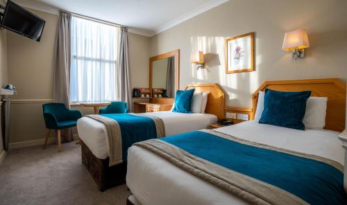 都柏林哈考特酒店的酒店客房设有两张床和电视。