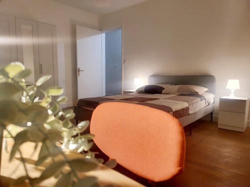 图卢兹Maison de charme的一间卧室配有一张床和一张橙色椅子