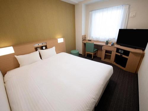 大阪The Rise Osaka Namba的酒店客房设有一张大床和一台电视。