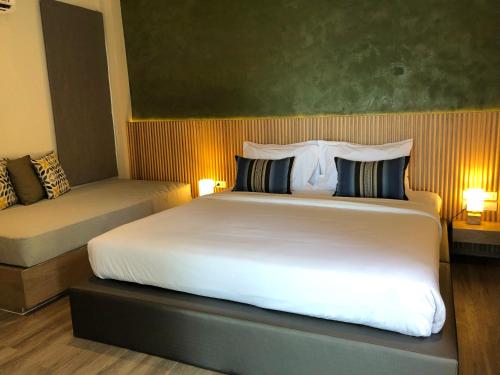 班拉克海滩Punnpreeda Beach Resort - SHA Plus Certified的卧室配有一张白色的大床和一张沙发。